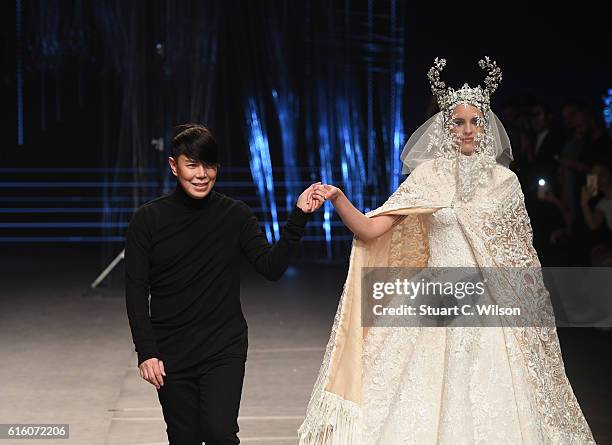 Designer Ezra poses with a model at the runway after the Ezra show during Fashion Forward Spring/Summer 2017 at the Dubai Design District on October...