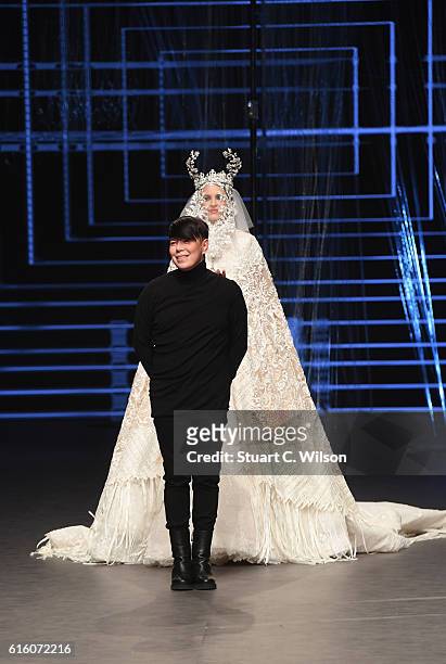 Designer Ezra poses with a model at the runway after the Ezra show during Fashion Forward Spring/Summer 2017 at the Dubai Design District on October...