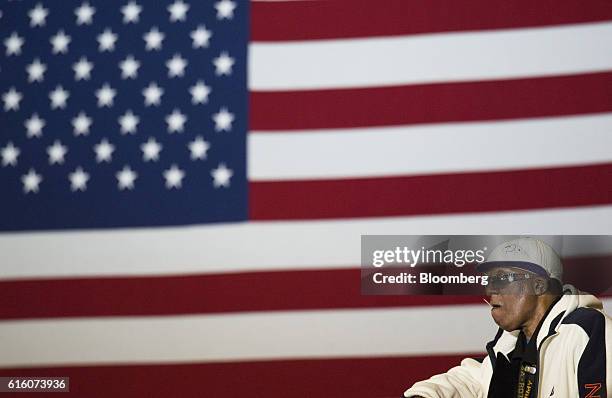 An attendee sits in front of an American flag before the start of a campaign rally with Hillary Clinton, 2016 Democratic presidential nominee, in...