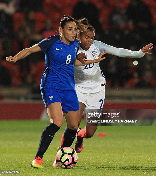 France's Jessica Houara takes on England's Nikita Parris during the women's international friendly football match between England and France at the...