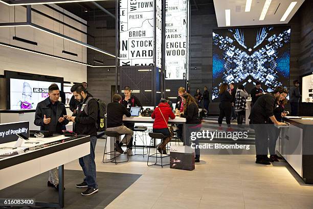 Employees assist customers at a T-Mobile US Inc. Store in Chicago, Illinois, U.S., on Friday, Oct. 21, 2016. T-Mobile US Inc. Is scheduled to release...