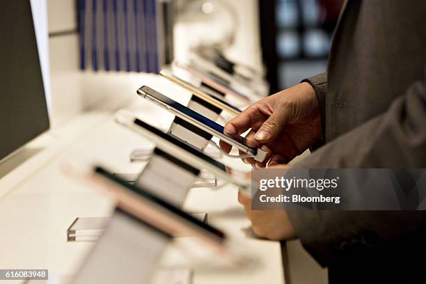 Shopper looks over a display of Apple Inc. IPhones at a T-Mobile US Inc. Store in Chicago, Illinois, U.S., on Friday, Oct. 21, 2016. T-Mobile US Inc....