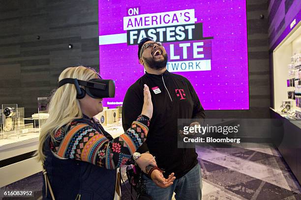 An employee reacts as a shopper tests an Oculus Rift virtual reality headset at a T-Mobile US Inc. Store in Chicago, Illinois, U.S., on Friday, Oct....
