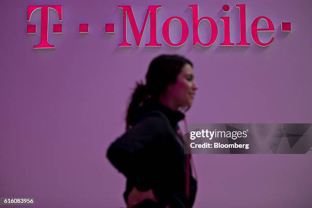 An employee stands near signage at a T-Mobile US Inc. Store in Chicago, Illinois, U.S., on Friday, Oct. 21, 2016. T-Mobile US Inc. Is scheduled to...