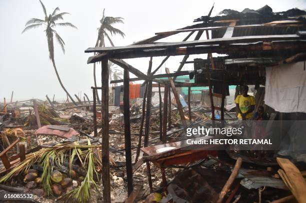 Esperance and her son Stevenson take shelter in their home, that was damaged in hurricane Matthew, while the rain falls during a tropical storm in...