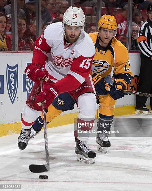 Riley Sheahan of the Detroit Red Wings skates with the puck as Matt Carle of the Nashville Predators pressures him during an NHL game at Joe Louis...