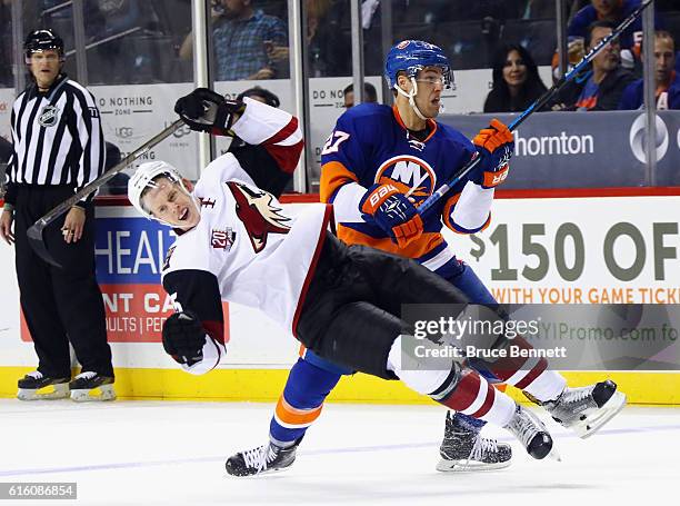 Anders Lee of the New York Islanders checks Connor Murphy of the Arizona Coyotes during the second period at the Barclays Center on October 21, 2016...