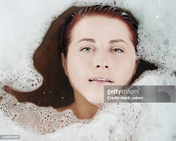 bath time - woman bath tub wet hair stock pictures, royalty-free photos & images