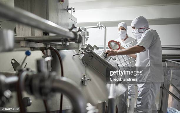 people working at a dairy factory - melkprodukt stockfoto's en -beelden