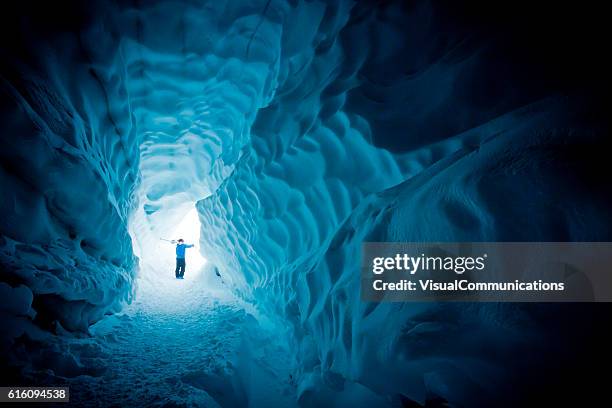 skier exploring ice cave. - gletsjer stockfoto's en -beelden