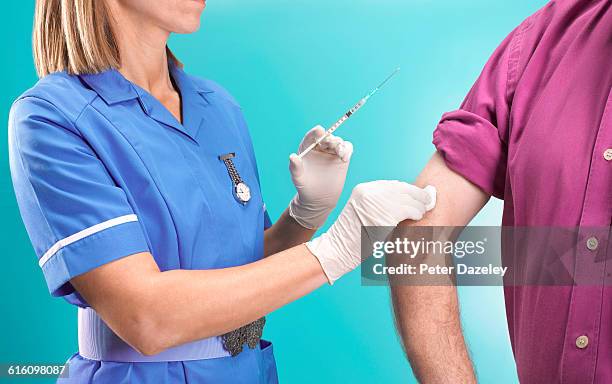 nurse giving flu jab to senior man - idea studio shot stockfoto's en -beelden