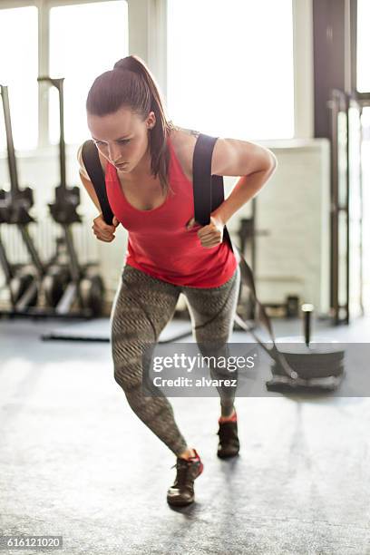 mujer tirando de trineo en el gimnasio - sledge fotografías e imágenes de stock