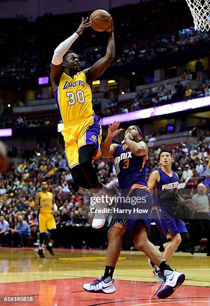 Julius Randle of the Los Angeles Lakers scores on a layup past Jared Dudley of the Phoenix Suns during a preseason game at Honda Center on October...