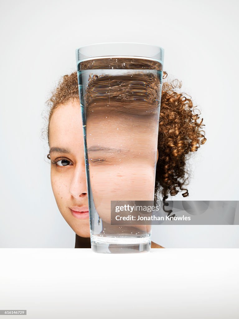 Portrait of female through glass of water