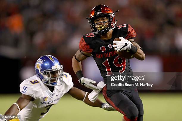 Donnel Pumphrey of the San Diego State Aztecs runs past Jermaine Kelly of the San Jose State Spartans for a touchdown during the first half of a game...