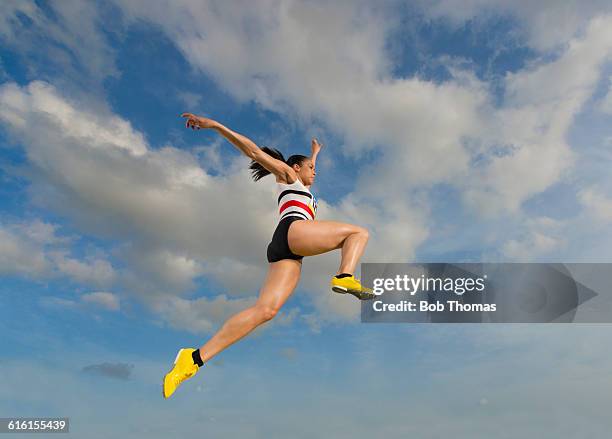 female long jump athlete in action - mens long jump stockfoto's en -beelden