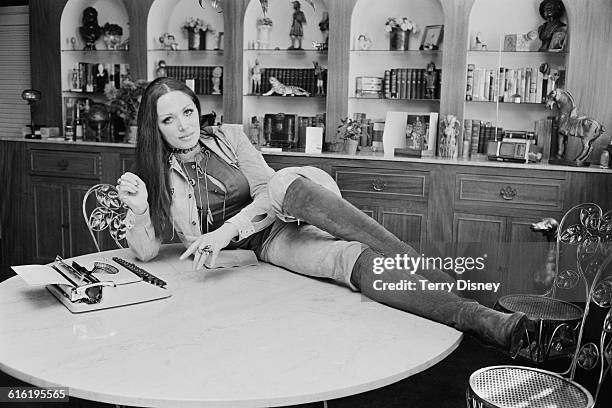 English novelist Jackie Collins poses with a typewriter, UK, 22nd March 1971.