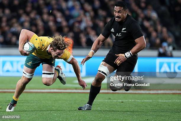 Michael Hooper of Australia trips while chased by Jerome Kaino of the All Blacks during the Bledisloe Cup Rugby Championship match between the New...