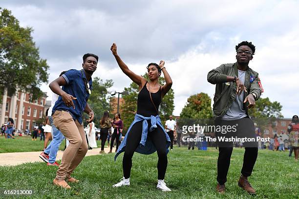 From left to right, Josh Howard, Tamika Henderson and Romario Rickett dance in the courtyard of Howard University as they celebrate homecoming with...