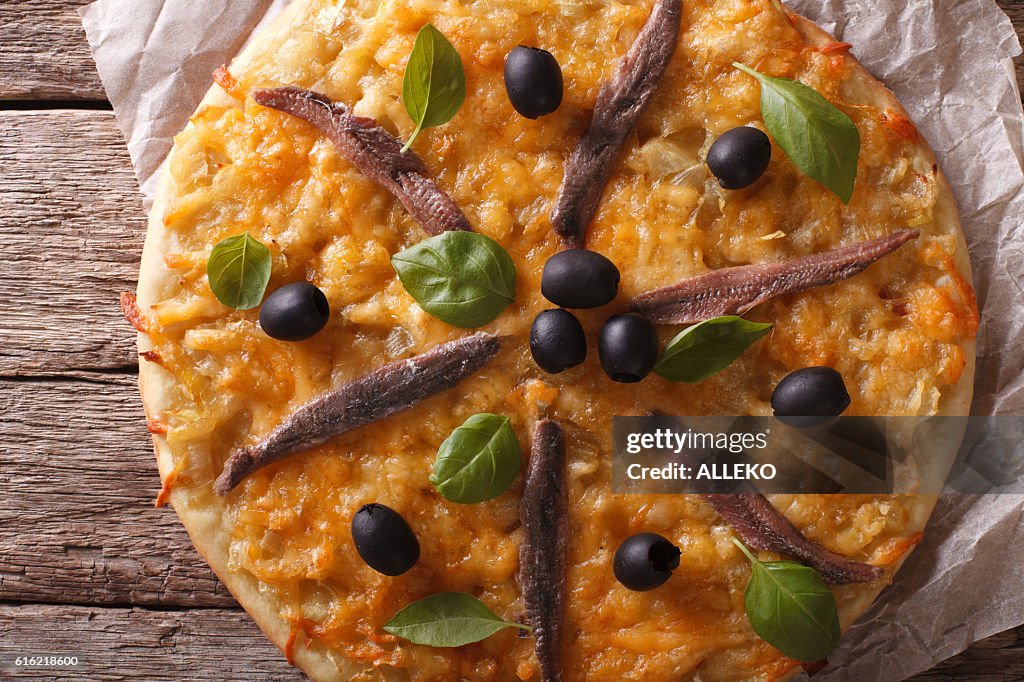 Pissaladiere with anchovies, olives and onion closeup. horizontal