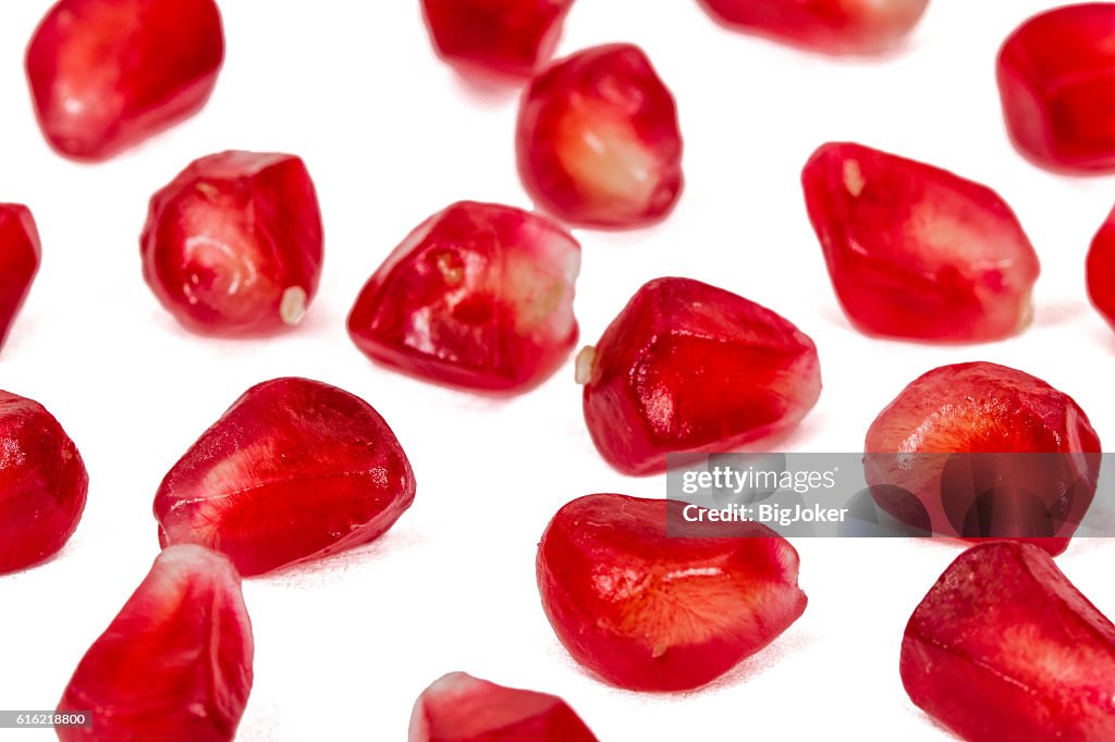 Ripe pomegranate seeds, isolated on white background