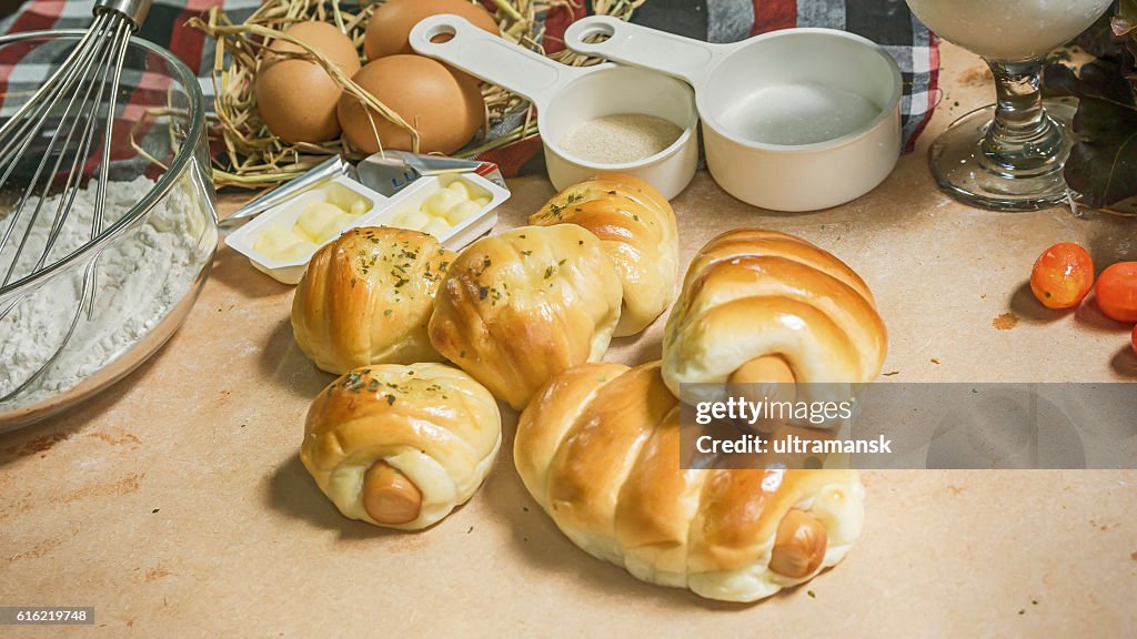 Bread sausage roll on the wood table with ingredient.