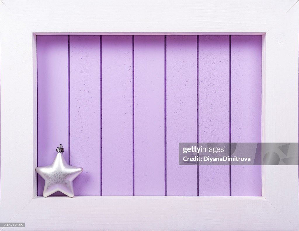 White wooden frame and  christmas decoration over a purple background