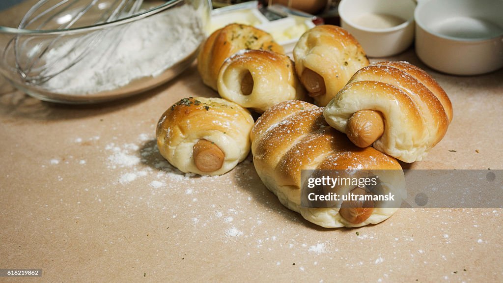 Bread sausage roll on the wood table with ingredient.