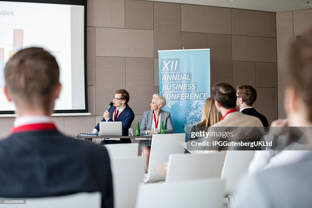 Businessman giving presentation in seminar hall