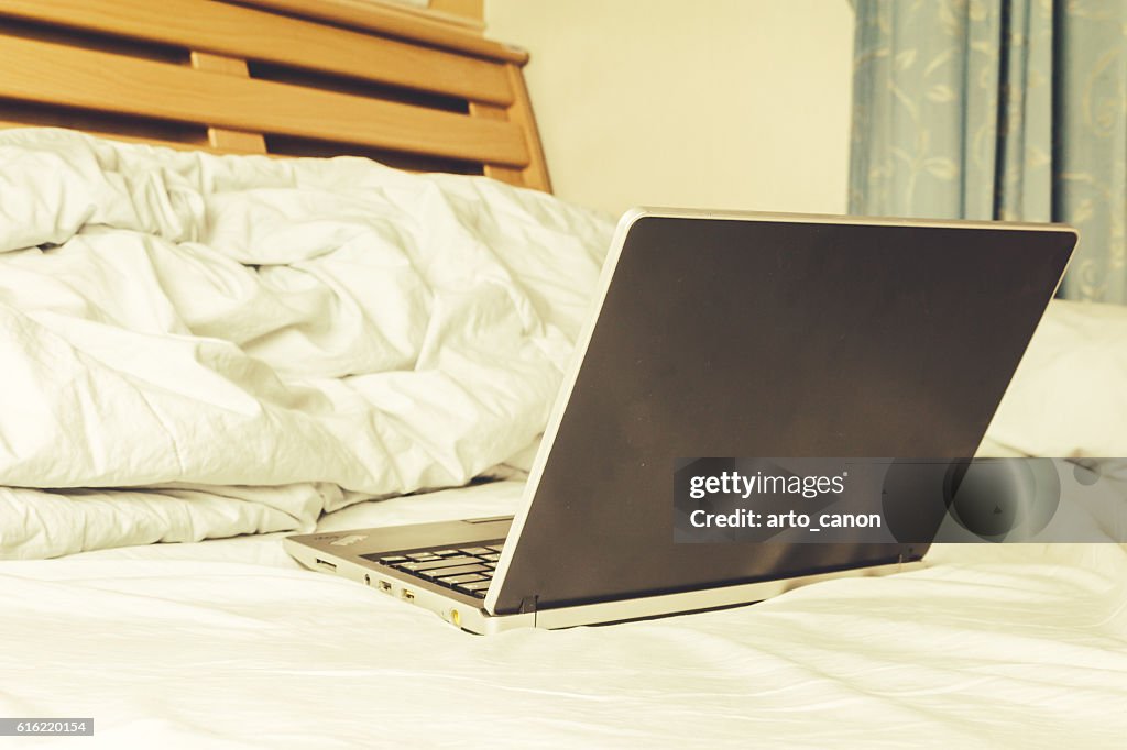 Black laptop on the bed