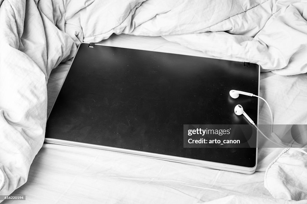 Black laptop on the bed
