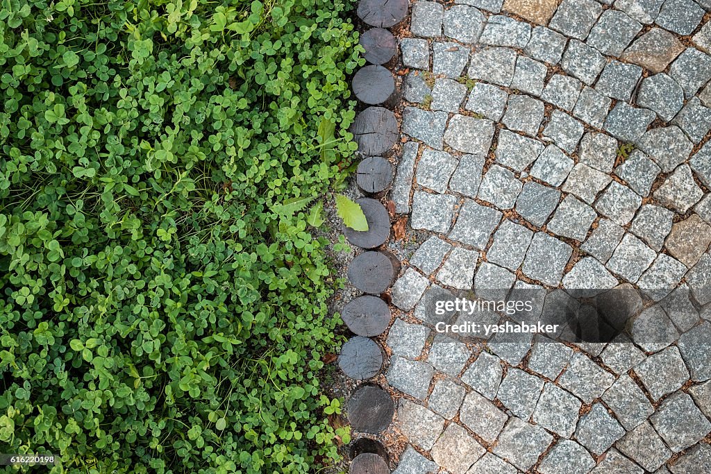 Short grass lawn and cobblestone pavement texture