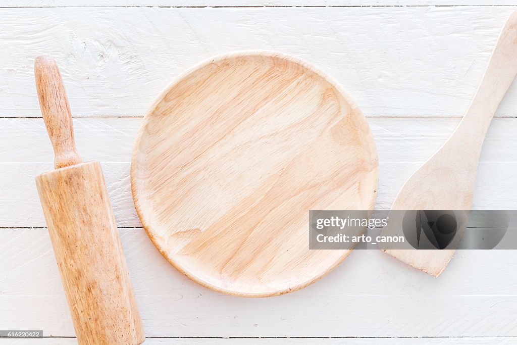 Küchenutensilien aus Holz auf weißem Küchentisch