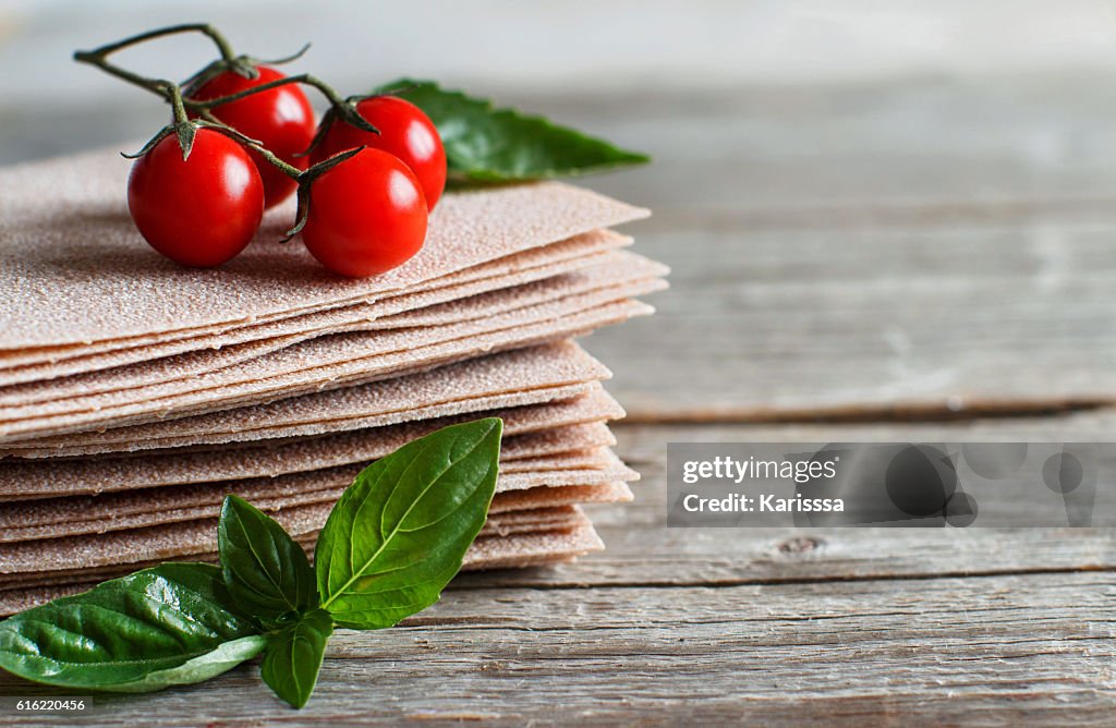 Raw lasagna sheets,basil and cherry tomatoes