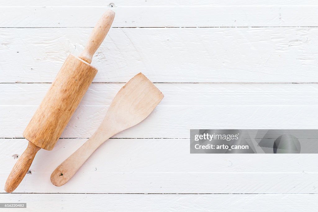 Wooden kitchen utensils on white  wooden background