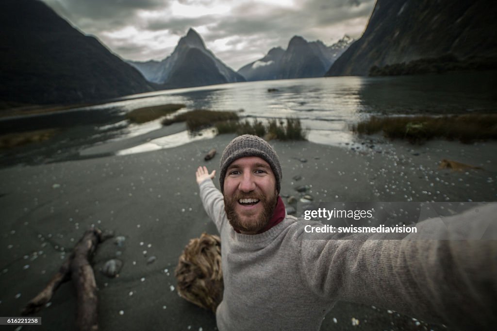 旅行者はミルフォードサウンド、ニュージーランドで自分撮りを取ります