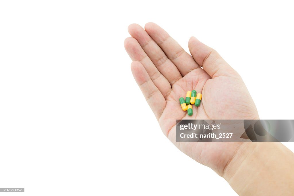 Hand of a man with some capsule pills