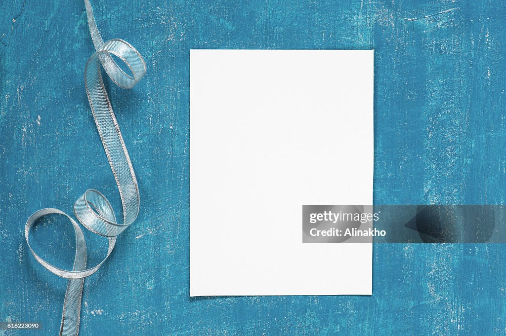 Painted aged blue background with blank sheet of paper