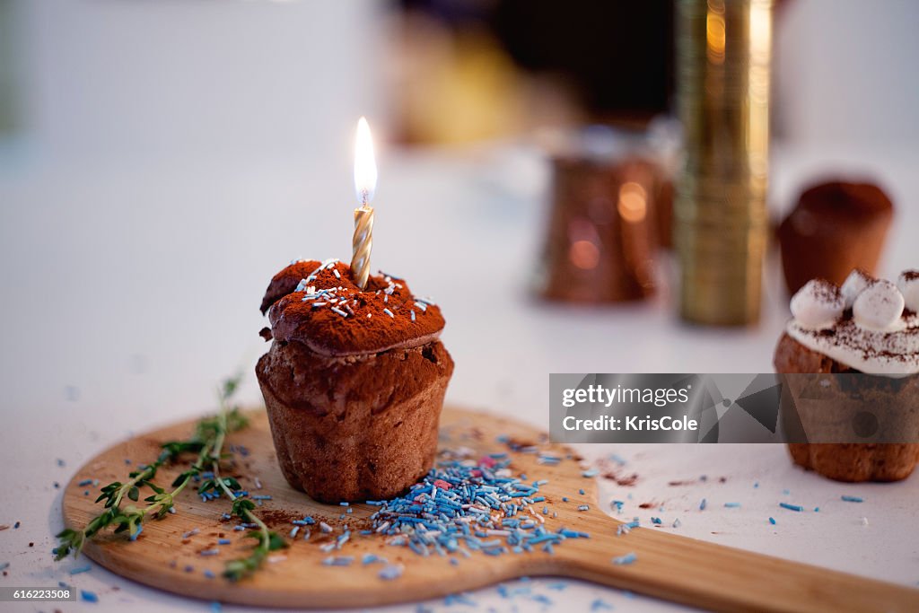 Lecker Geburtstag cupcake mit Kerze, auf dem Tisch, verschwommene Hintergrund