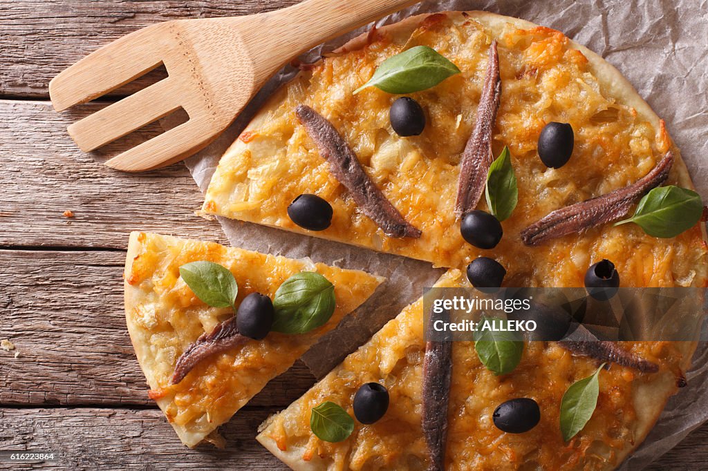 Sliced pizza with anchovies and onions close-up. horizontal top view