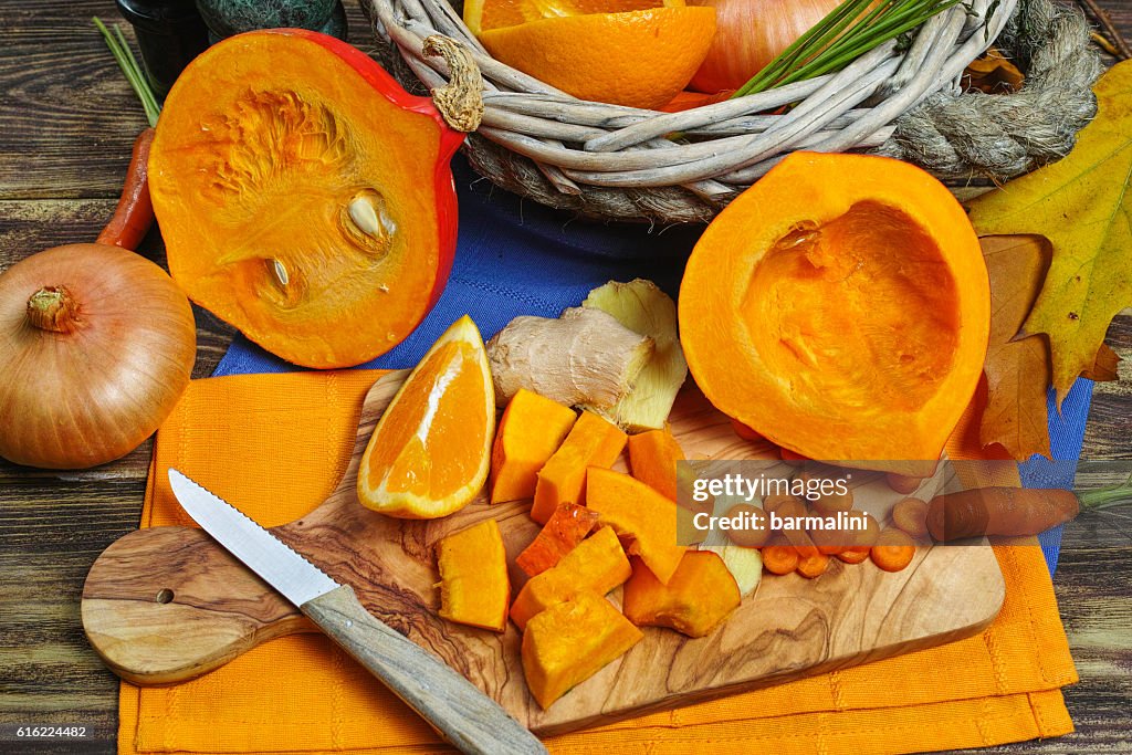 Fresh ingredients for pumpkin soup - apple, orange, carrot, onion