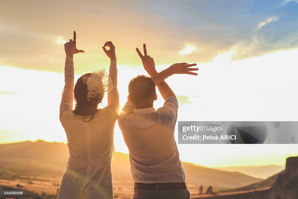 Newlyweds making heart sign