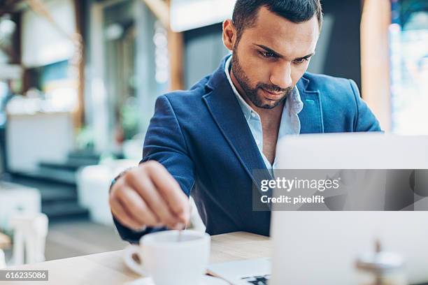 serious man looking at his laptop - middle east cool stock pictures, royalty-free photos & images