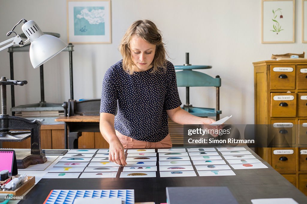 Female designer checking photos of ceramics