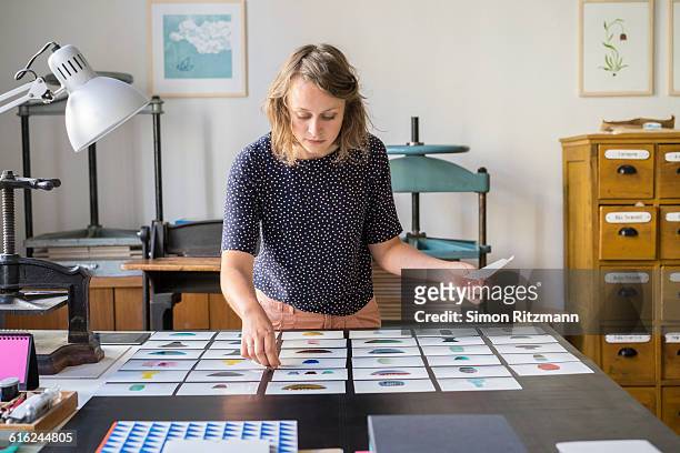female designer checking photos of ceramics - design professional stockfoto's en -beelden