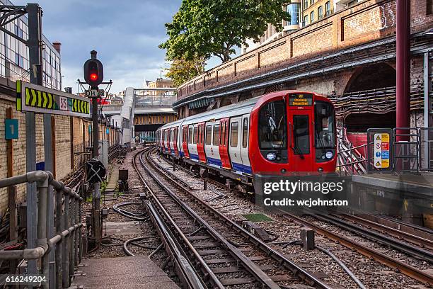 u-bahn-zug kommt am bahnhof farringdon an - bahnübergangsschild stock-fotos und bilder