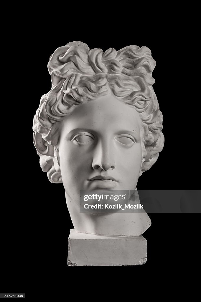 Gypsum statue of Apollo's head on a black background