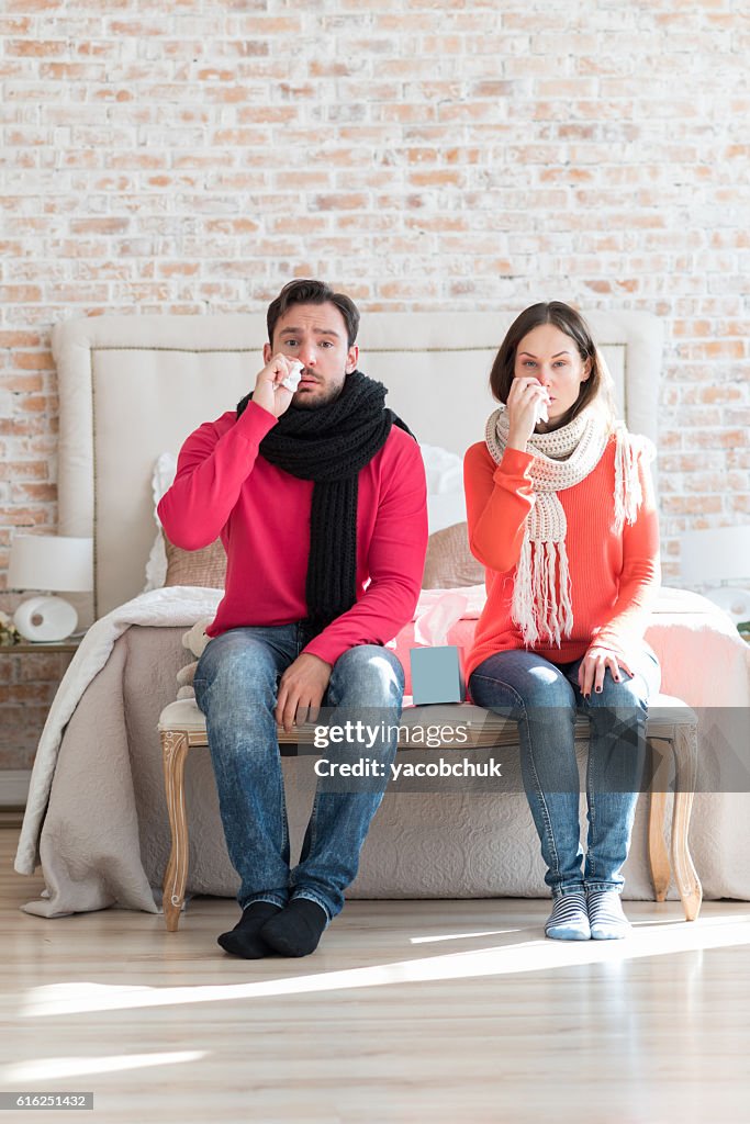 Unglückliches trauriges Paar leidet an Grippe