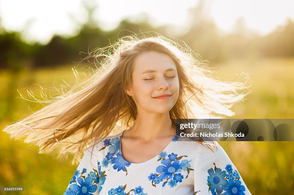 美しい少女のフラワーフィールド女性のフラワーフィールドの夕日