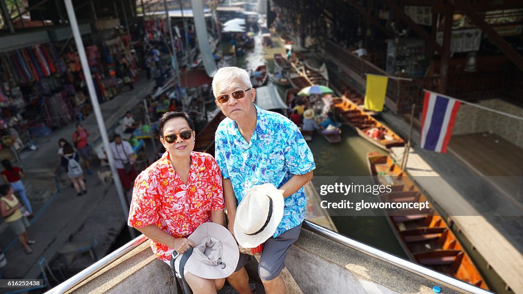 Asian elderly couple having retirement trip to Thailand floating